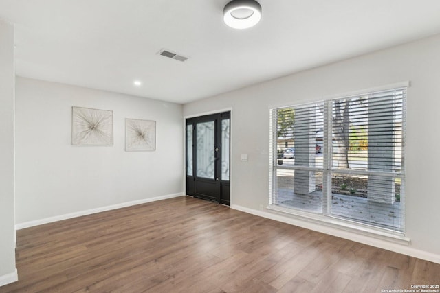 entrance foyer featuring visible vents, baseboards, and wood finished floors