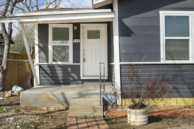 view of exterior entry featuring fence