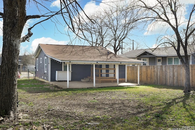 rear view of house featuring a yard, fence, and a patio