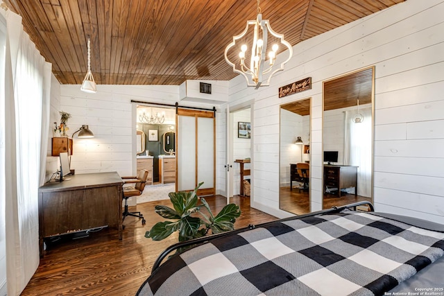 bedroom with a barn door, visible vents, wooden ceiling, wood finished floors, and an inviting chandelier