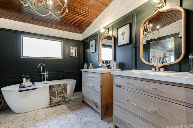 bathroom featuring lofted ceiling, wood ceiling, two vanities, a freestanding tub, and a sink