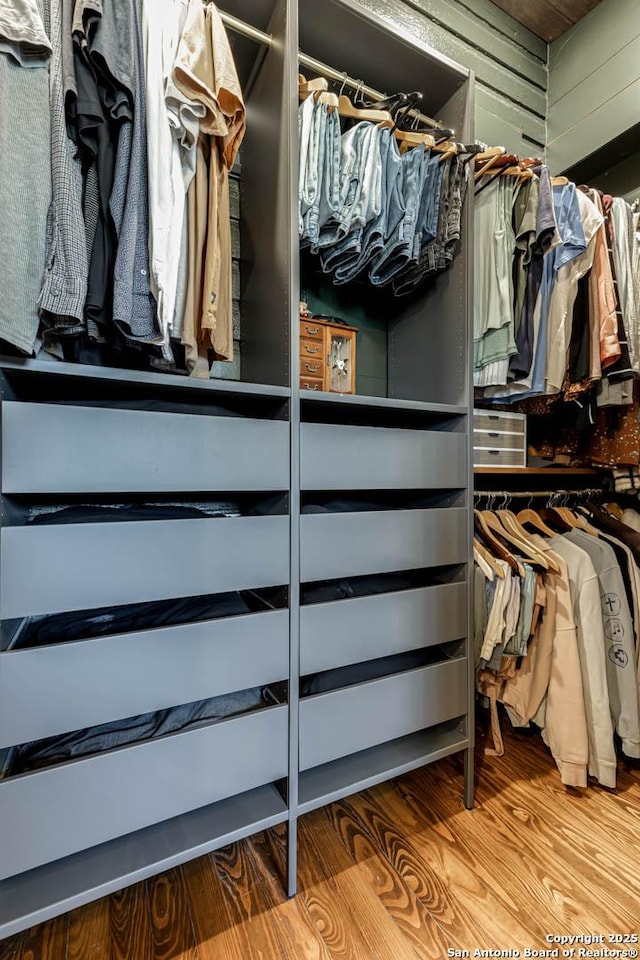 walk in closet with wood finished floors