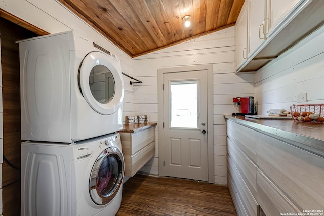 laundry room featuring wooden ceiling, wooden walls, stacked washing maching and dryer, cabinet space, and dark wood-style floors