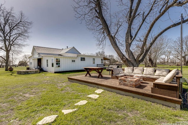 view of yard featuring a deck and an outdoor living space with a fire pit