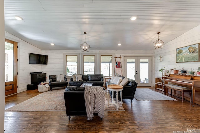 living room with dark wood-style floors, a chandelier, vaulted ceiling, and french doors