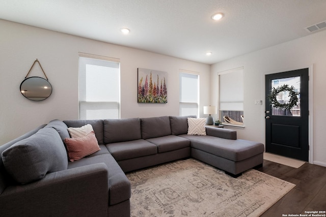 living room featuring visible vents, dark wood-type flooring, and recessed lighting