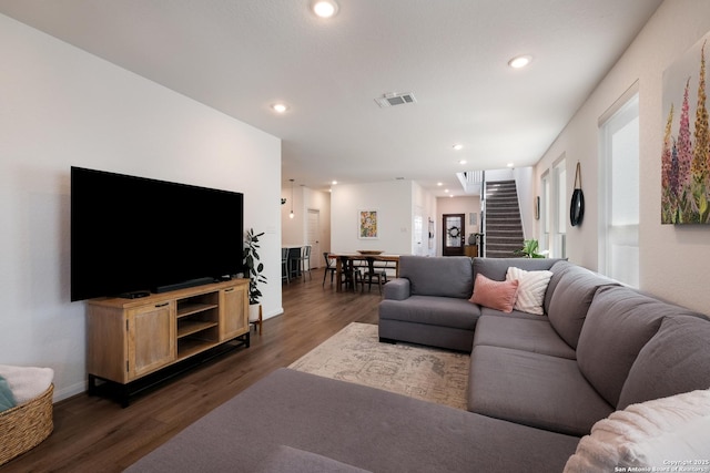 living room featuring dark wood-style floors, recessed lighting, and stairway