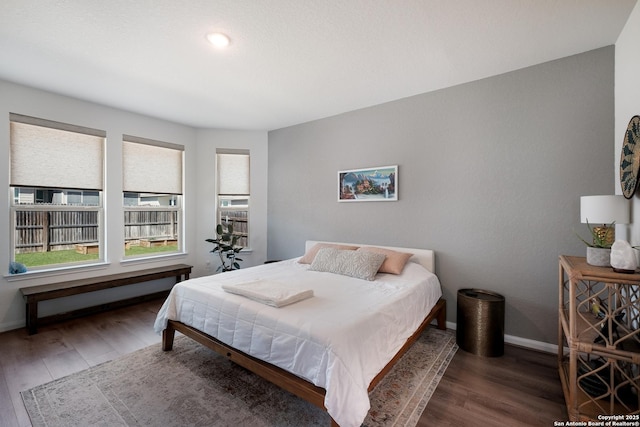 bedroom featuring baseboards and wood finished floors