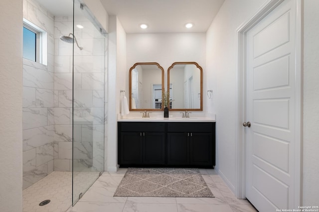 bathroom featuring marble finish floor, a sink, a marble finish shower, and double vanity