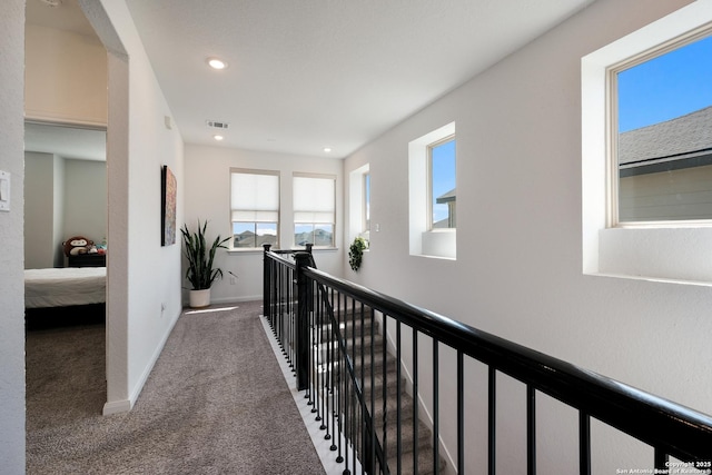 hallway featuring carpet, recessed lighting, visible vents, an upstairs landing, and baseboards