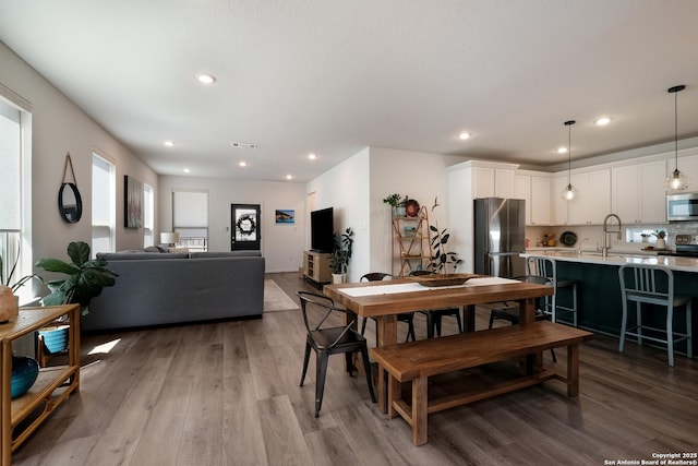 dining space featuring wood finished floors, visible vents, and recessed lighting