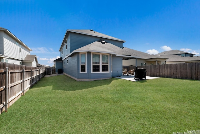 rear view of property featuring a lawn, a patio area, and a fenced backyard