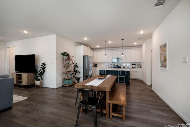 dining space featuring baseboards, visible vents, dark wood finished floors, and recessed lighting