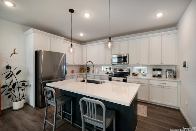 kitchen featuring stainless steel appliances, dark wood-style flooring, a sink, white cabinetry, and tasteful backsplash