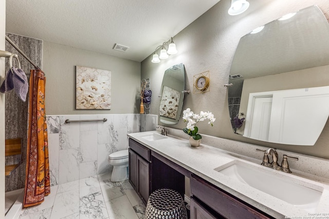 full bathroom with visible vents, a sink, a textured ceiling, and toilet