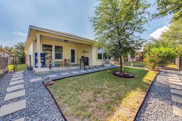 back of property with a patio, a lawn, and fence