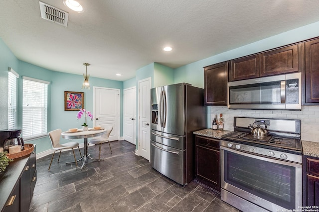 kitchen with light stone counters, stainless steel appliances, tasteful backsplash, visible vents, and dark brown cabinets