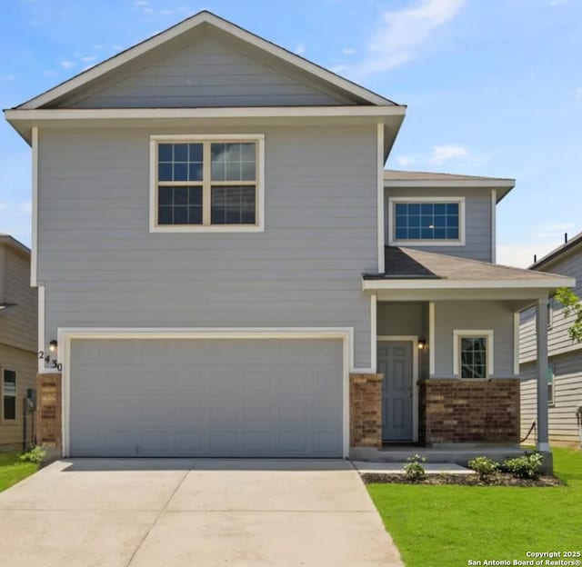 view of front of house featuring an attached garage, driveway, a front yard, and brick siding