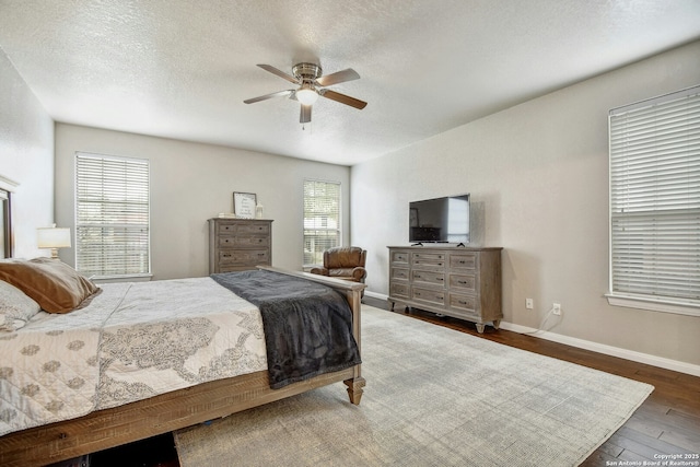 bedroom featuring a ceiling fan, a textured ceiling, baseboards, and wood finished floors