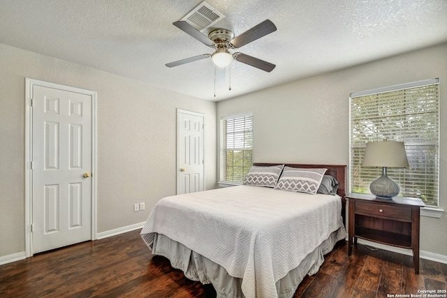 bedroom with a textured ceiling, baseboards, and wood finished floors