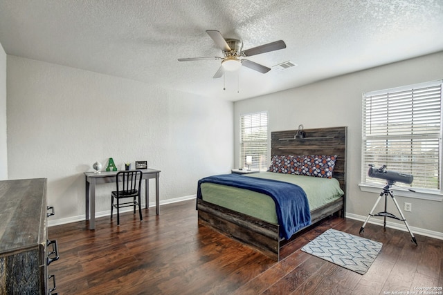 bedroom featuring wood-type flooring, visible vents, ceiling fan, a textured ceiling, and baseboards