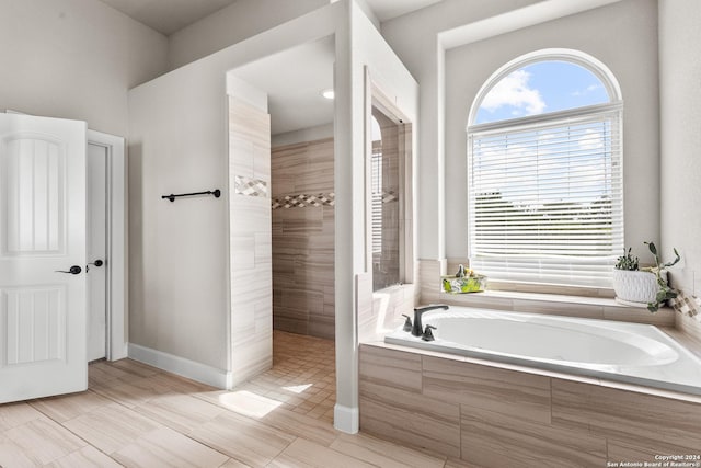 full bath featuring walk in shower, baseboards, and a bath