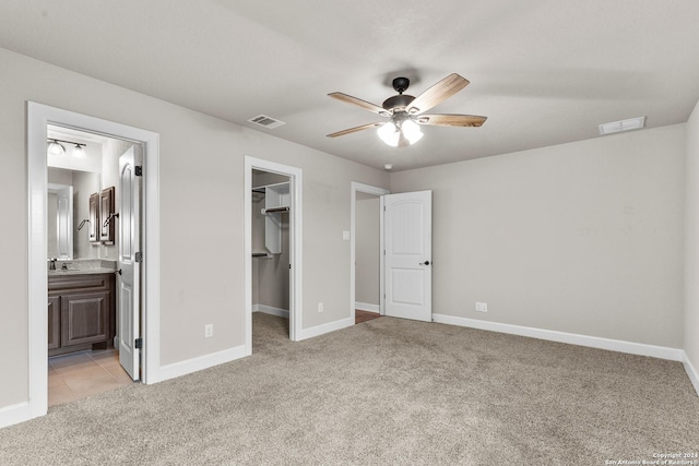 unfurnished bedroom featuring light carpet, a spacious closet, visible vents, and a closet