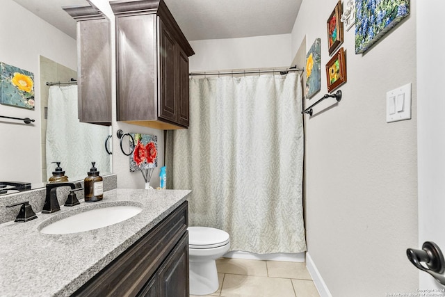 bathroom featuring toilet, vanity, baseboards, and tile patterned floors