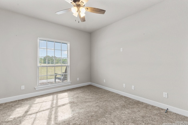 carpeted empty room with ceiling fan and baseboards