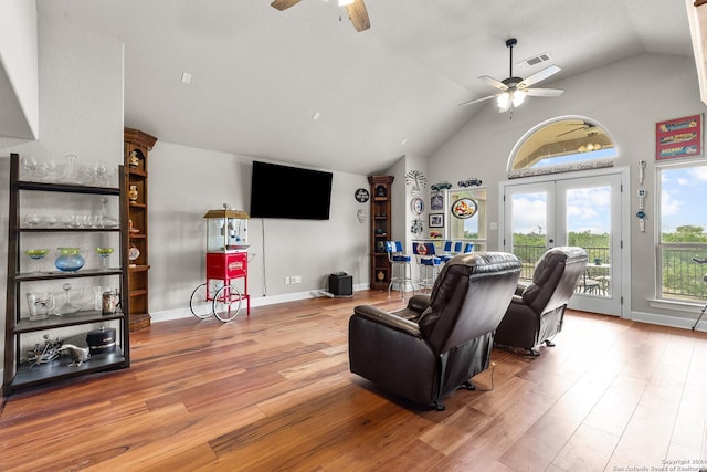 living area featuring ceiling fan, high vaulted ceiling, wood finished floors, visible vents, and french doors