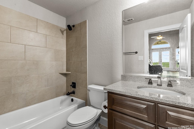 bathroom with visible vents, a textured wall, toilet, vanity, and shower / tub combination