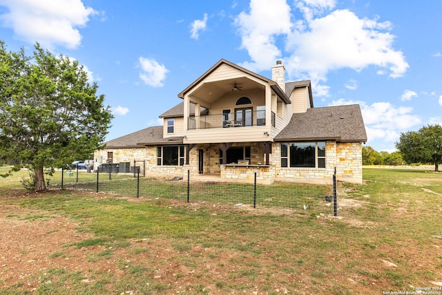 back of house featuring a ceiling fan, a patio, a balcony, fence, and a yard