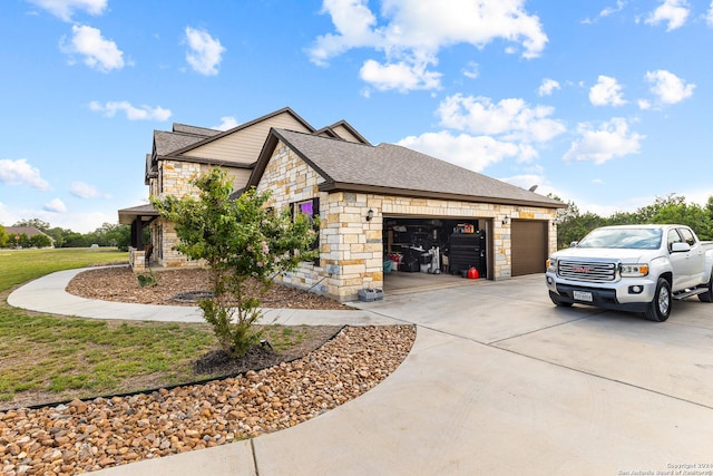 view of side of home featuring an attached garage, stone siding, a shingled roof, and concrete driveway