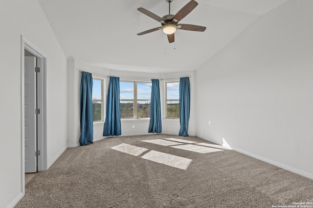 carpeted empty room featuring lofted ceiling, a ceiling fan, and baseboards