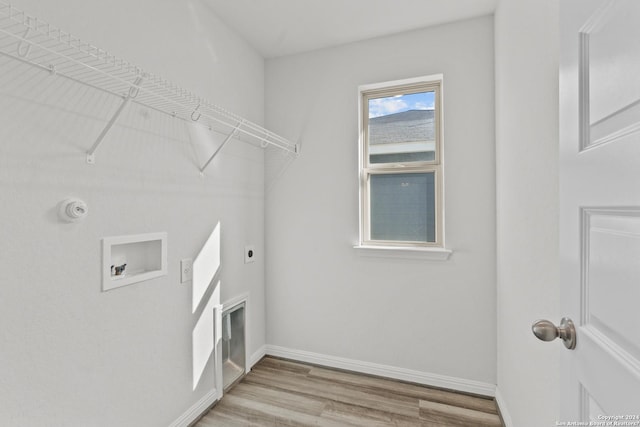 laundry room with laundry area, light wood finished floors, washer hookup, and baseboards