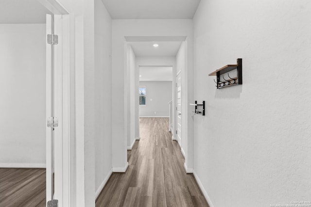 hall featuring dark wood-style floors and baseboards