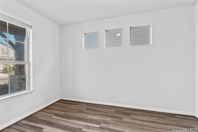 empty room with baseboards and wood finished floors