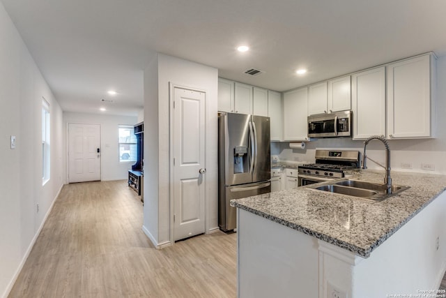 9211 Navarro Vis, Seguin, TX 78155 - kitchen featuring visible vents, a peninsula, stainless steel appliances, white cabinetry, and a sink