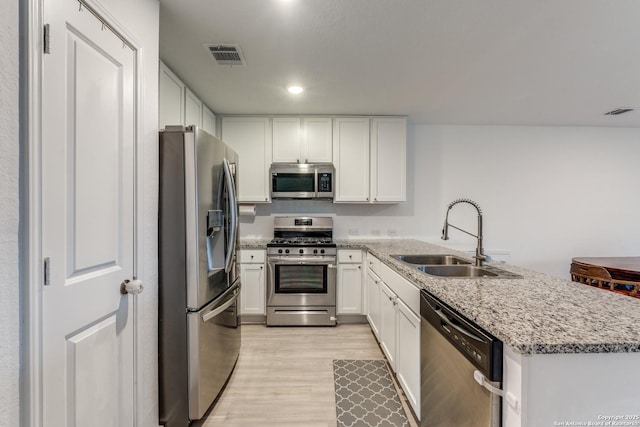 9211 Navarro Vis, Seguin, TX 78155 - kitchen with a peninsula, a sink, visible vents, appliances with stainless steel finishes, and light wood-type flooring