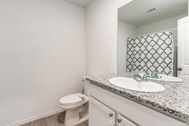9211 Navarro Vis, Seguin, TX 78155 - bathroom with visible vents, toilet, vanity, wood finished floors, and baseboards