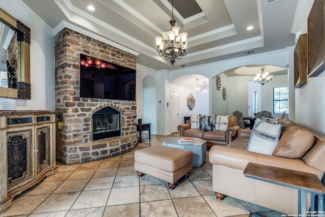 living area with arched walkways, ornamental molding, a tray ceiling, a fireplace, and a notable chandelier