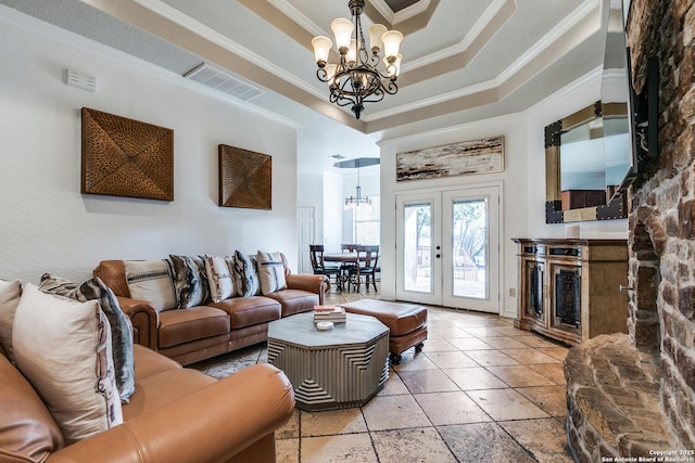 living area with an inviting chandelier, visible vents, a raised ceiling, and french doors