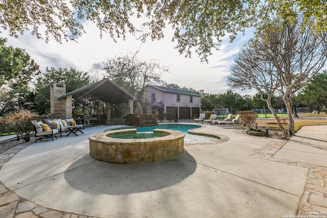 view of pool featuring a pool with connected hot tub, a patio, a gazebo, and an outdoor hangout area