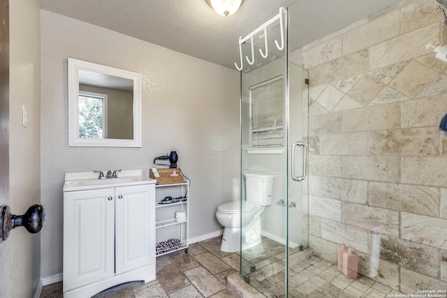 full bath with toilet, a stall shower, baseboards, and vanity