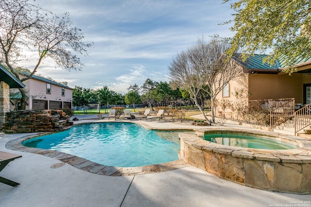 view of pool featuring a patio, fence, and a pool with connected hot tub