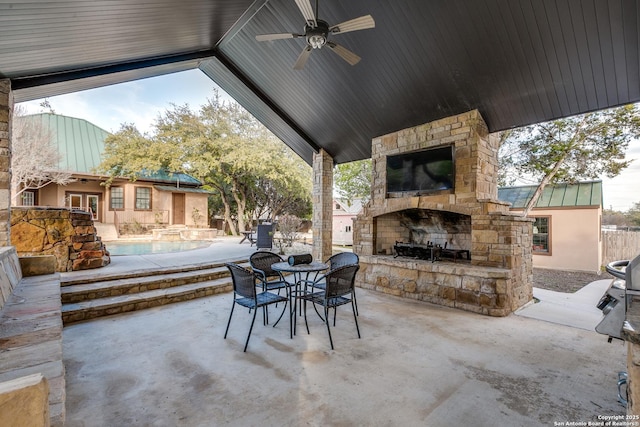 view of patio / terrace featuring an outdoor stone fireplace, outdoor dining area, and a ceiling fan