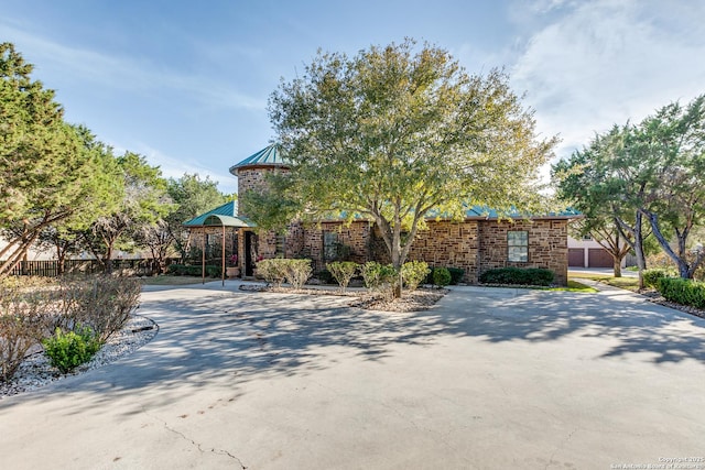 view of front of property with metal roof, brick siding, a standing seam roof, and fence