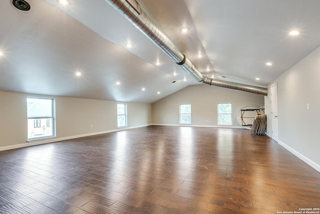 unfurnished living room featuring dark wood-style floors, plenty of natural light, and baseboards