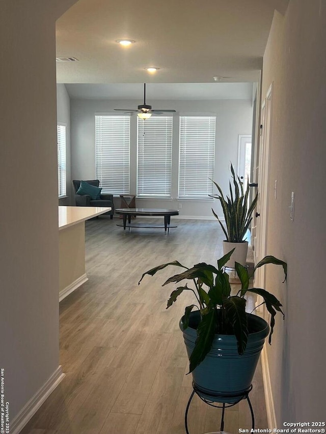 corridor with baseboards and wood finished floors