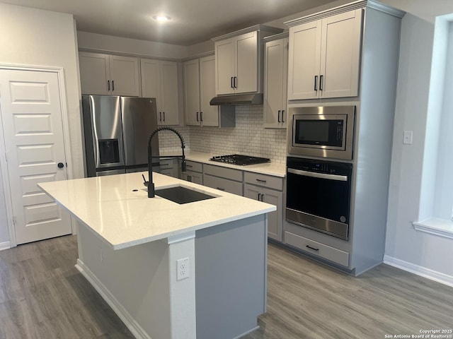 kitchen featuring appliances with stainless steel finishes, gray cabinets, and a sink